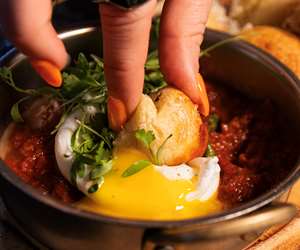 Dipping Pizza Munchkins in Shakshuka sauce