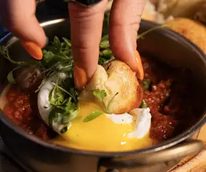 Dipping Pizza Munchkins in Shakshuka sauce