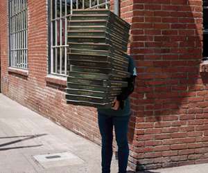 Far Corner employee holding a stack of pizza boxes