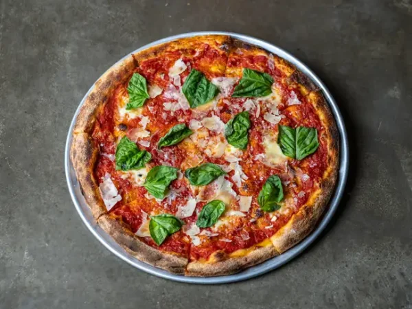 Margherita Pizza with basil, tomato sauce and parmesan on a metal tray