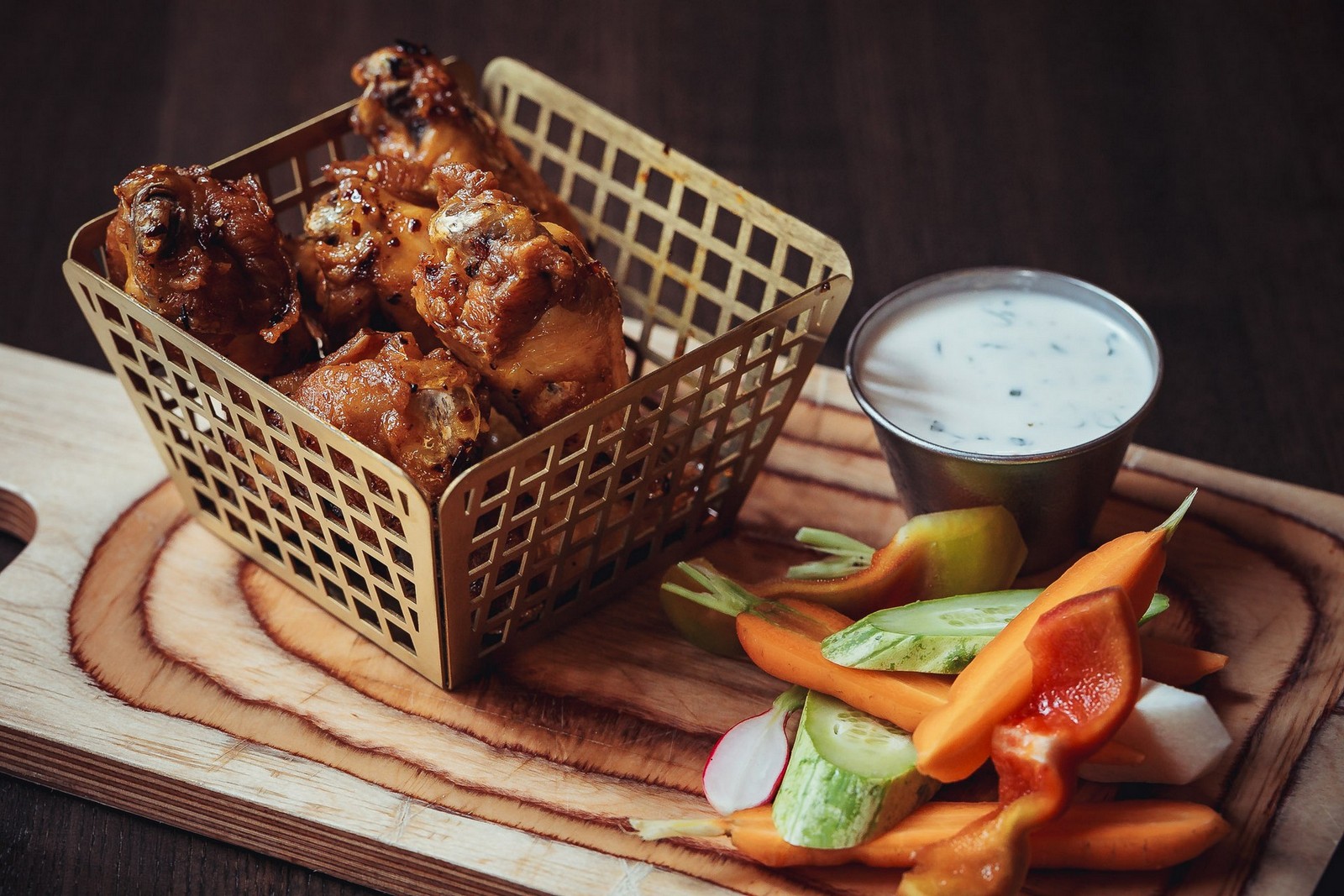Basket of chicken wings San Diego diners order with ranch and fresh vegetables