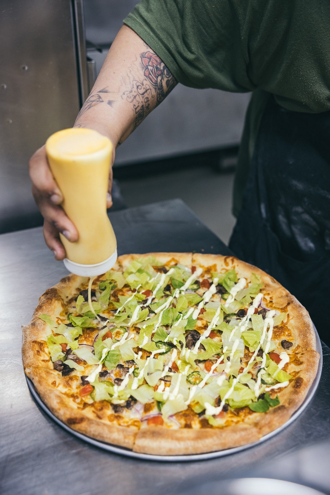 Drizzling sauce on a Caesar pizza - Far Corner Drizzling sauce on a Caesar pizza - Far Corner