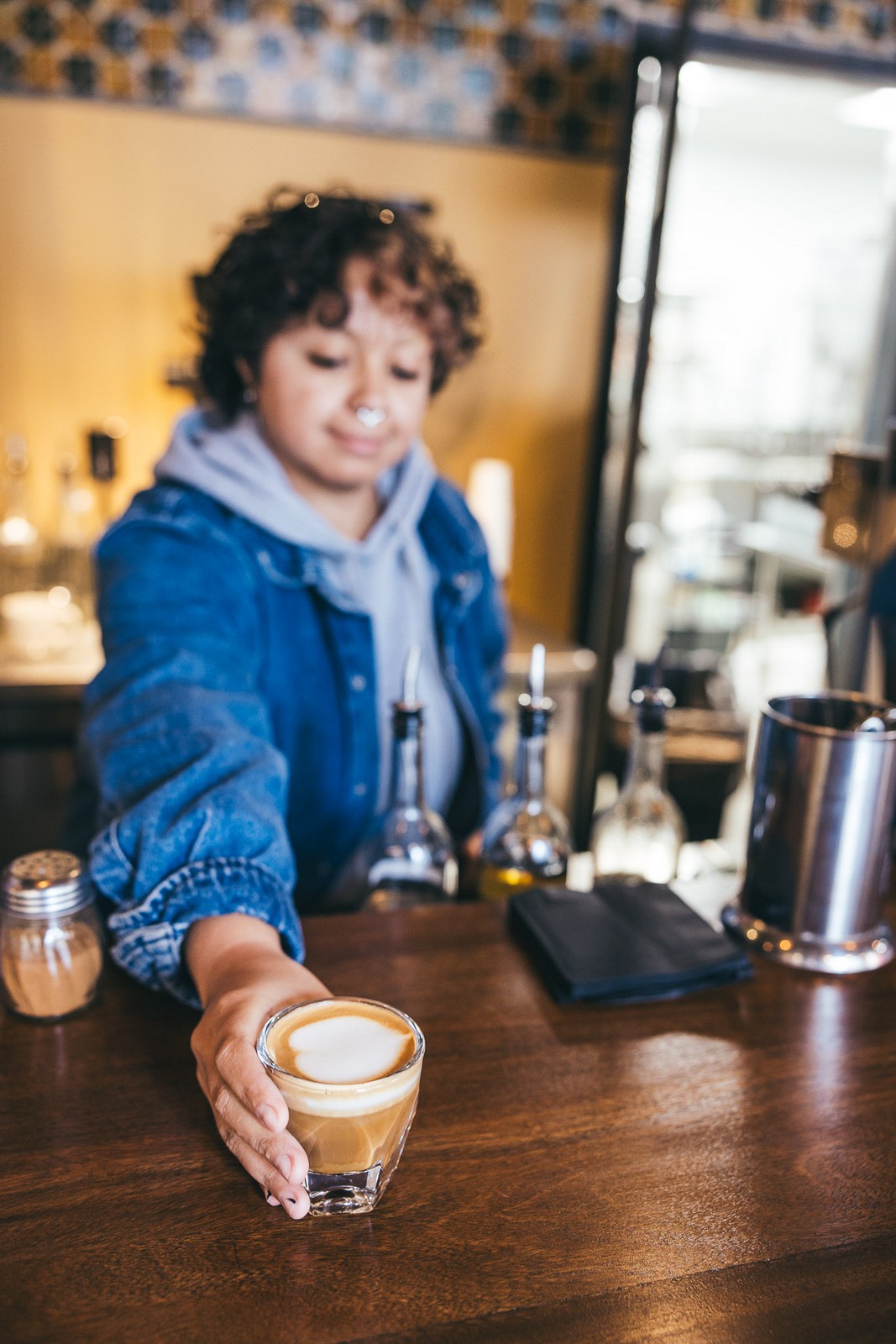 Barista handing over a coffee at the Far Corner coffee bar in downtown San Diego Barista handing over a coffee at the Far Corner coffee bar in downtown San Diego